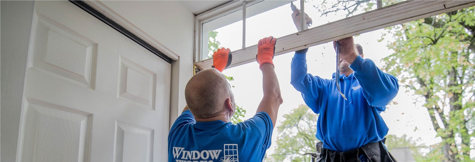 Team of contractors installing a custom entry door with sidelights