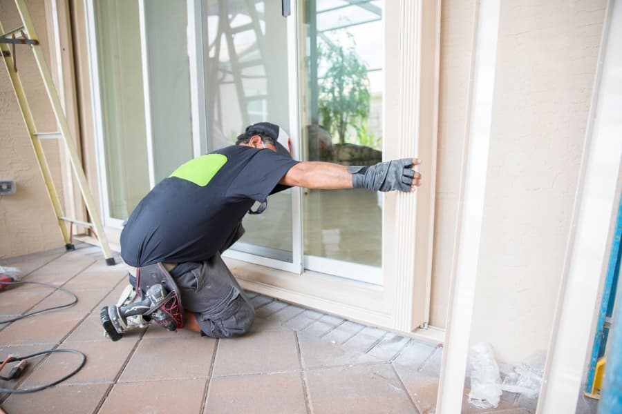 Professional installing a storm door over a new entry door