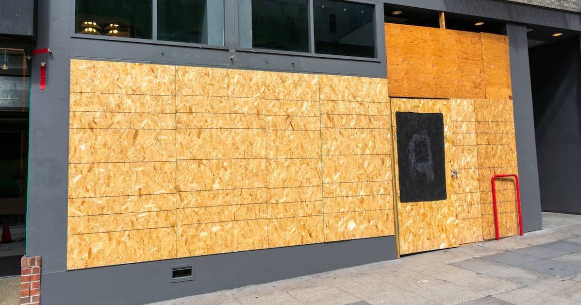 Emergency board-up services securing a commercial building exterior with plywood panels