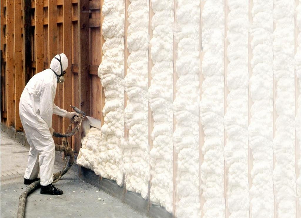 Contractor applying spray foam insulation to an open wall for energy efficiency