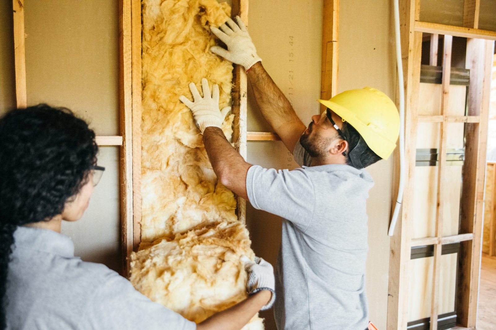 Contractors installing weatherization materials in a residential home