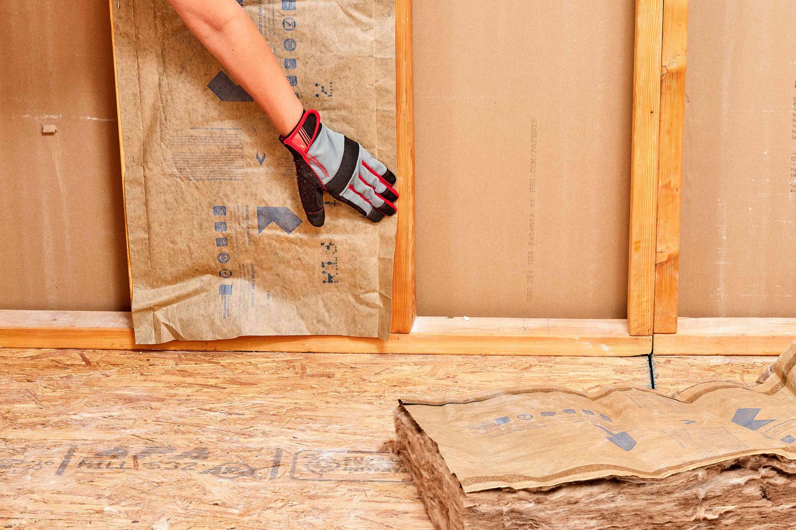 Worker installing blown-in insulation in a residential attic