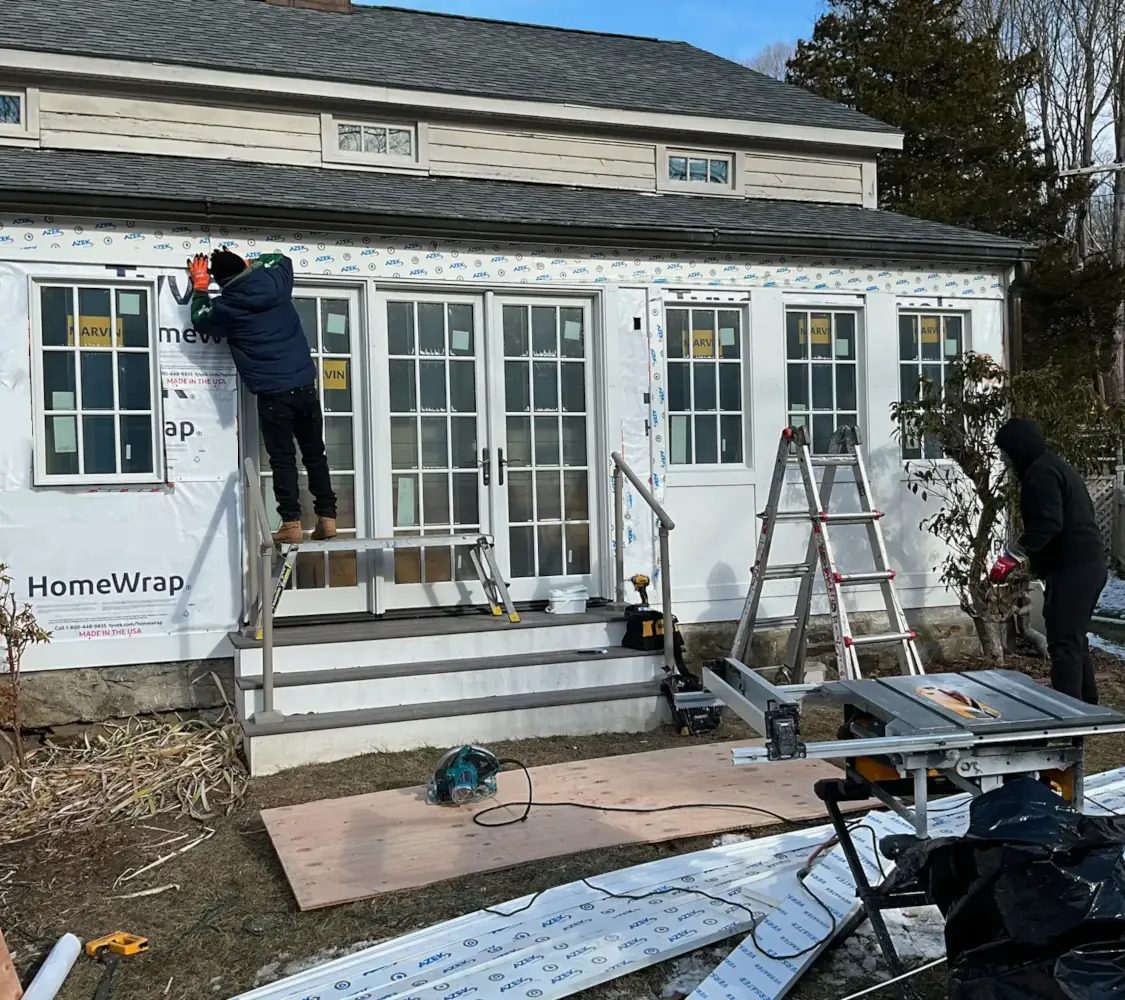 Professional installing energy-efficient replacement windows on a home exterior