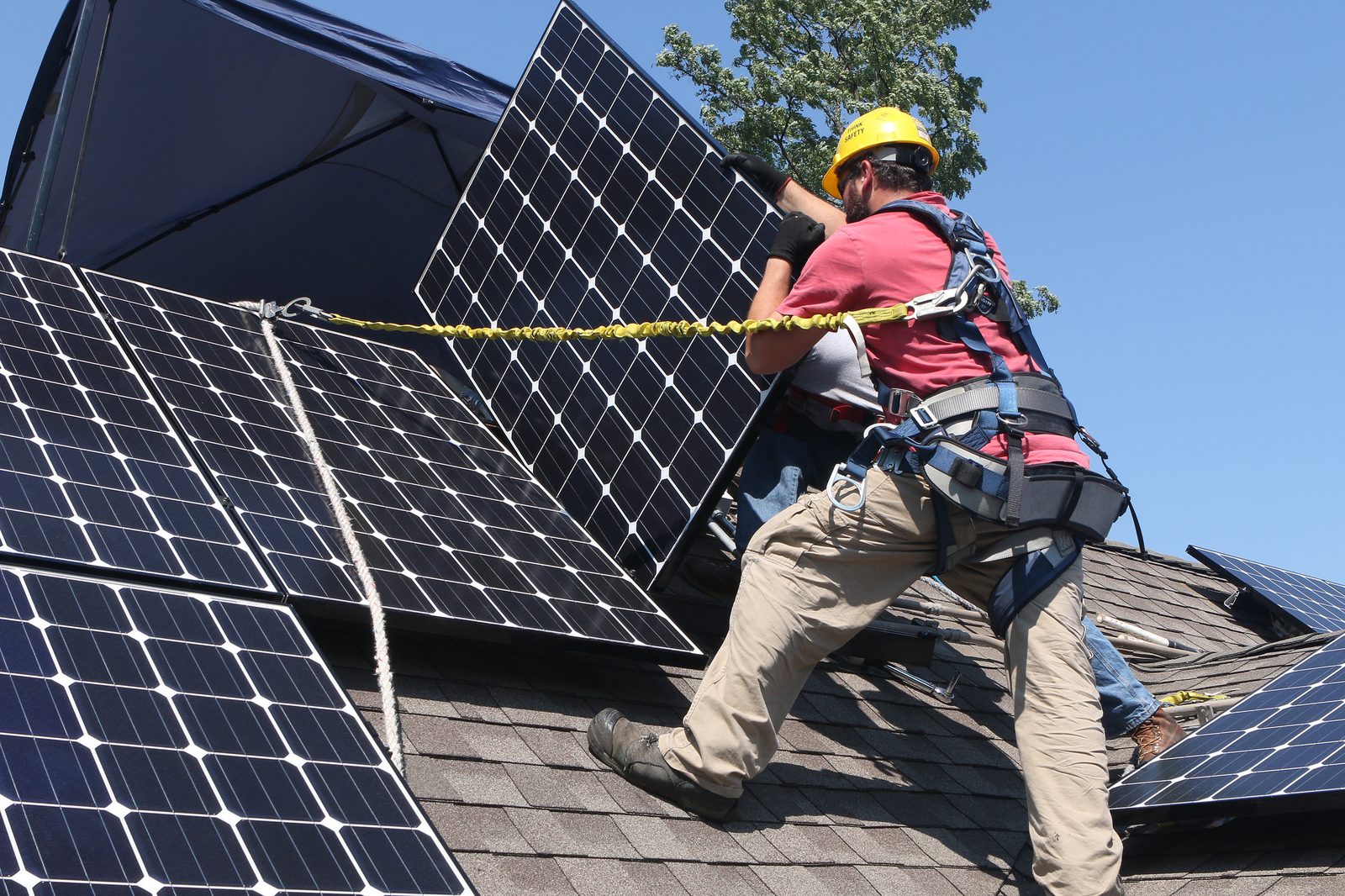 Contractors installing solar panels on a residential roof