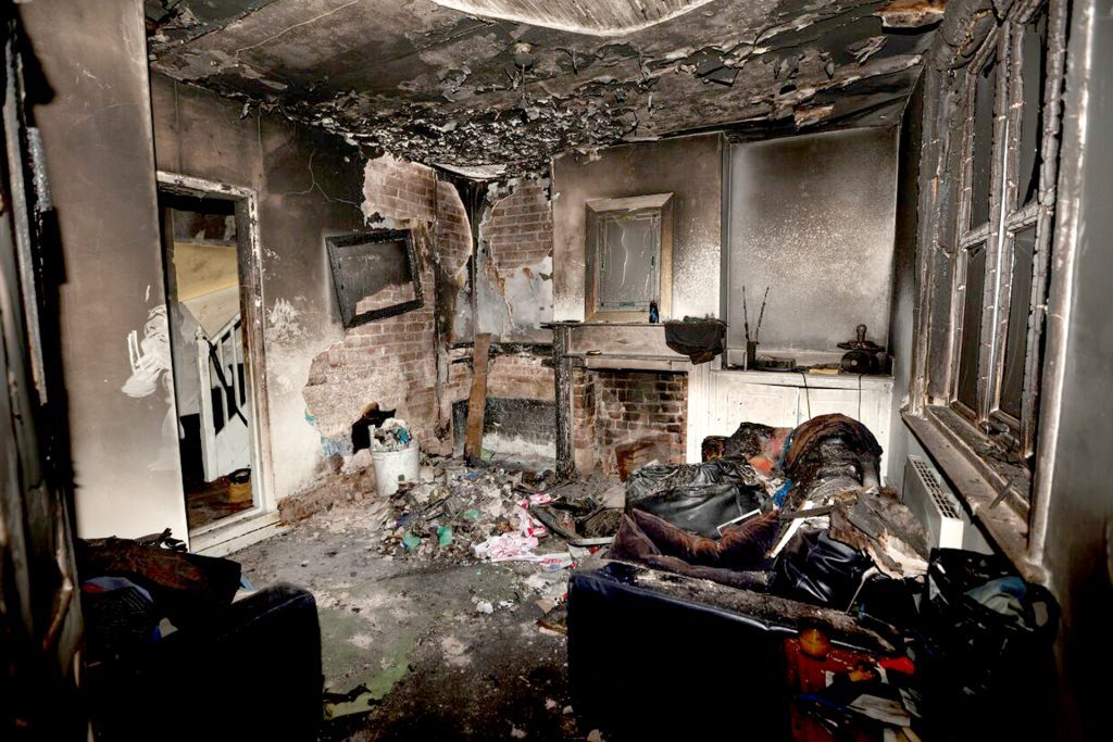 Extensive fire and smoke damage visible in a residential living room awaiting restoration