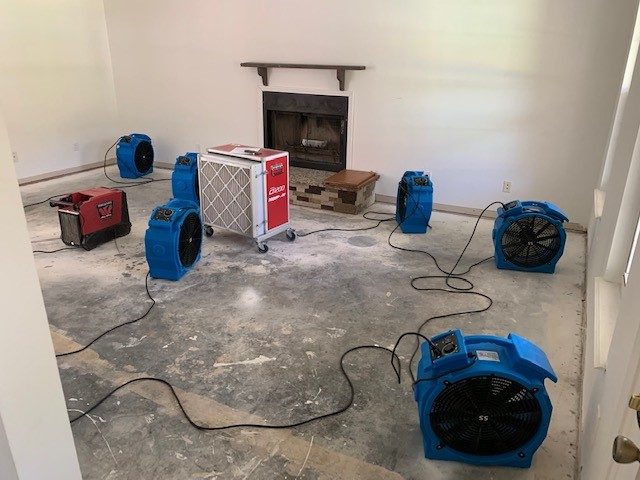 Drying equipment and dehumidifiers placed in a room for water damage restoration