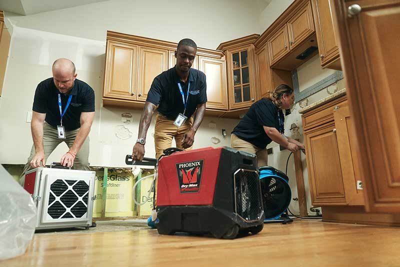 Technicians setting up professional drying equipment for flood and water restoration