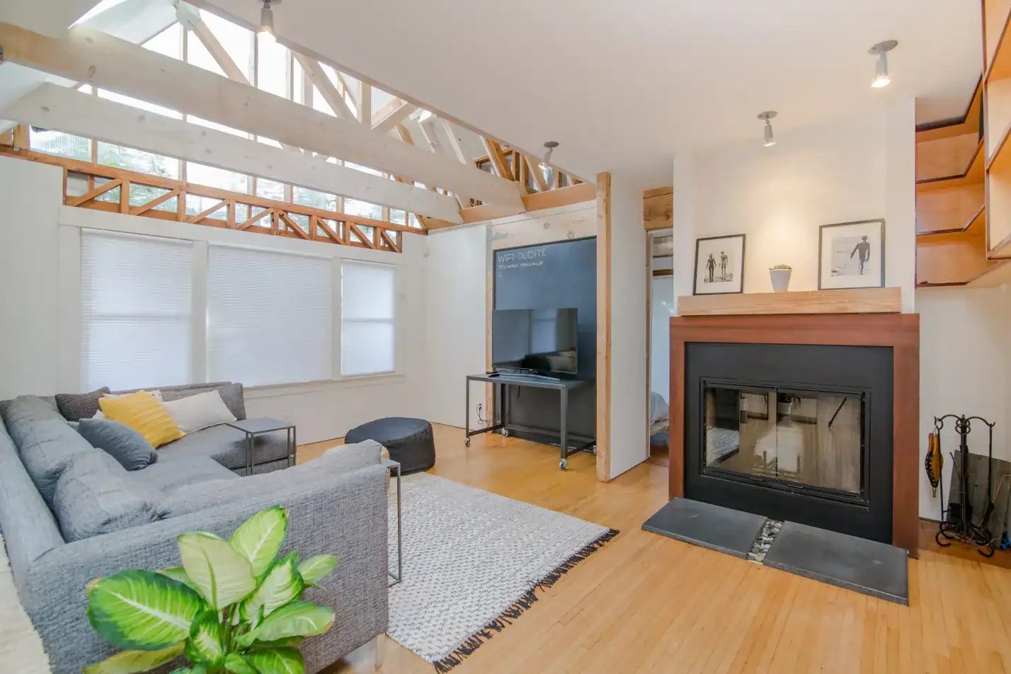 Spacious living room with vaulted ceilings and modern fireplace during general remodeling