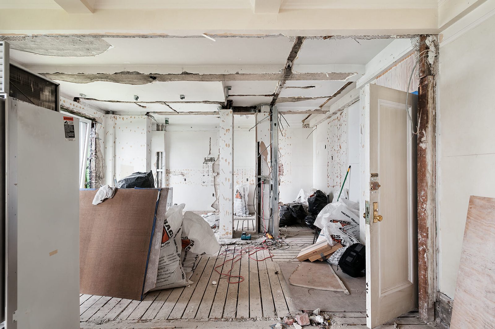 Contractor measuring and installing custom shelving during general remodeling