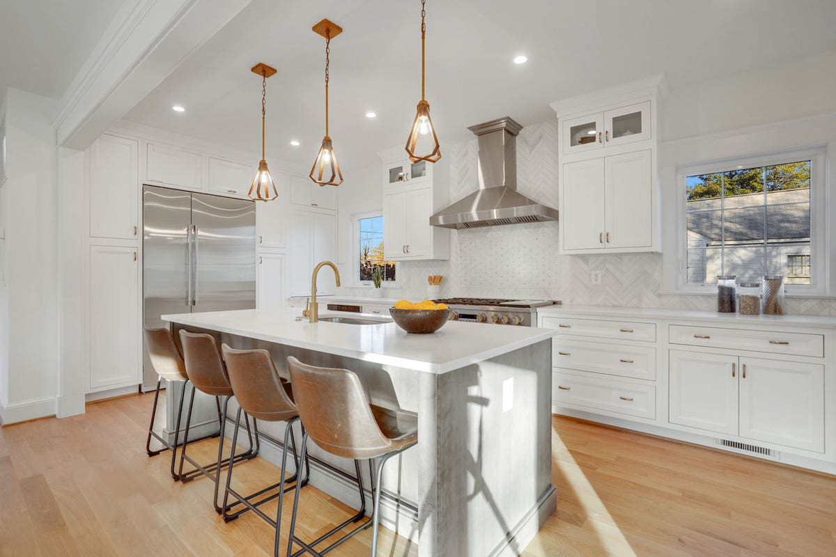 High-end kitchen renovation with white inset cabinets and a large central island