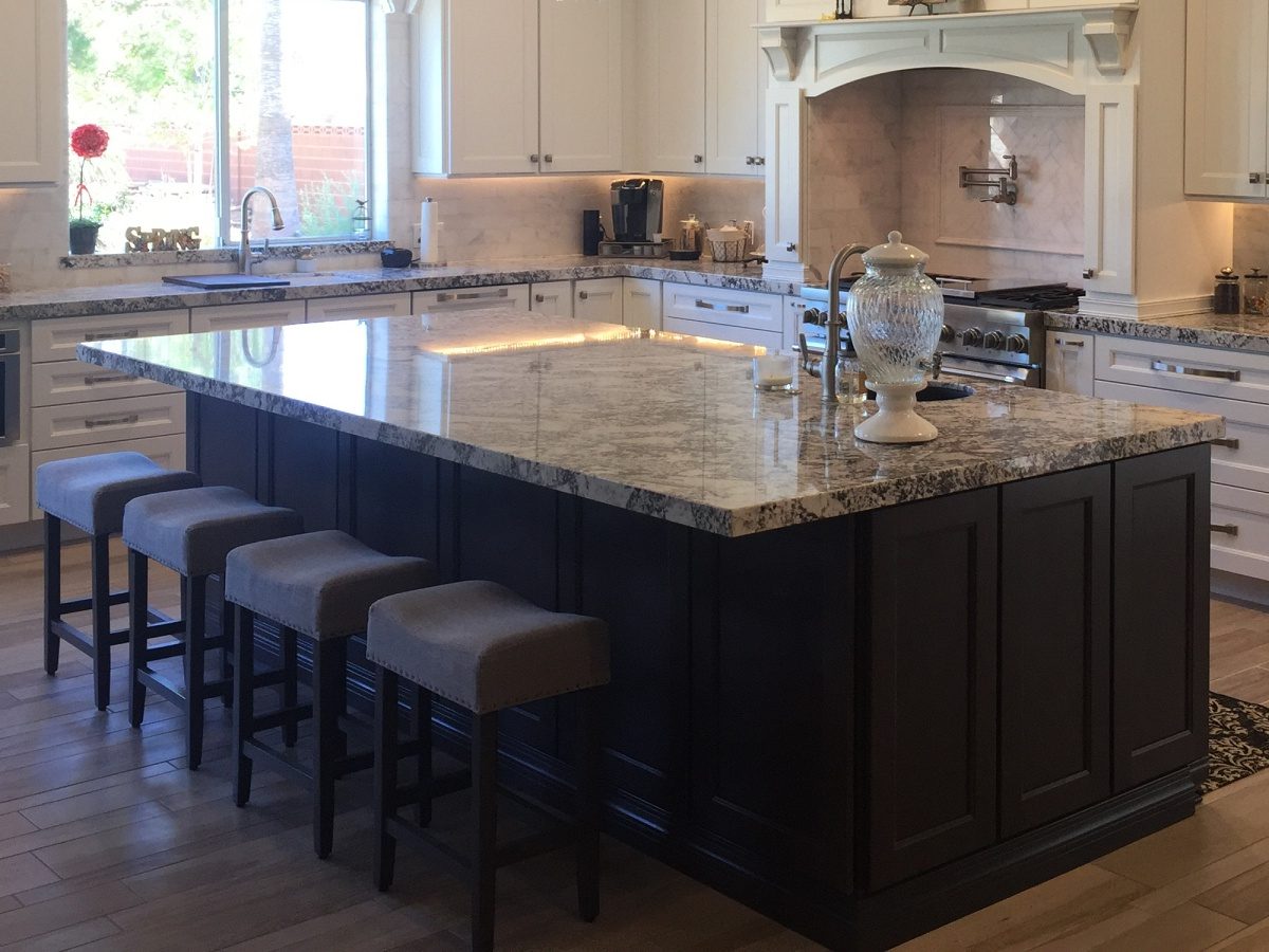 Spacious kitchen remodel showcasing a dark wood island and white cabinetry