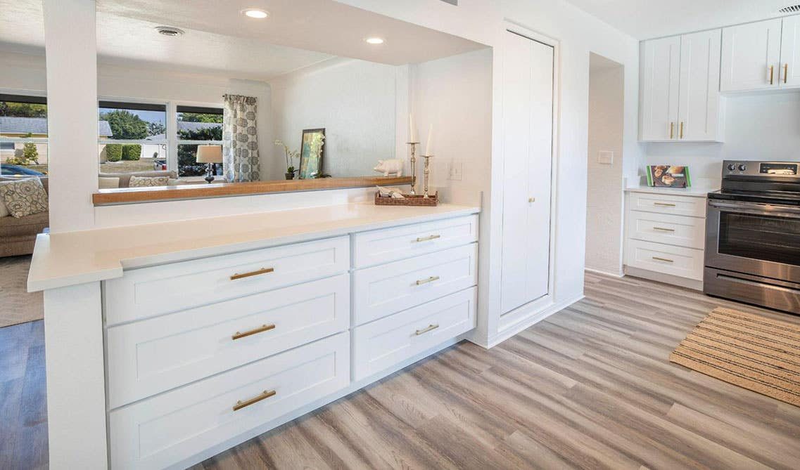 Remodeled kitchen with timeless white shaker cabinets and a breakfast bar