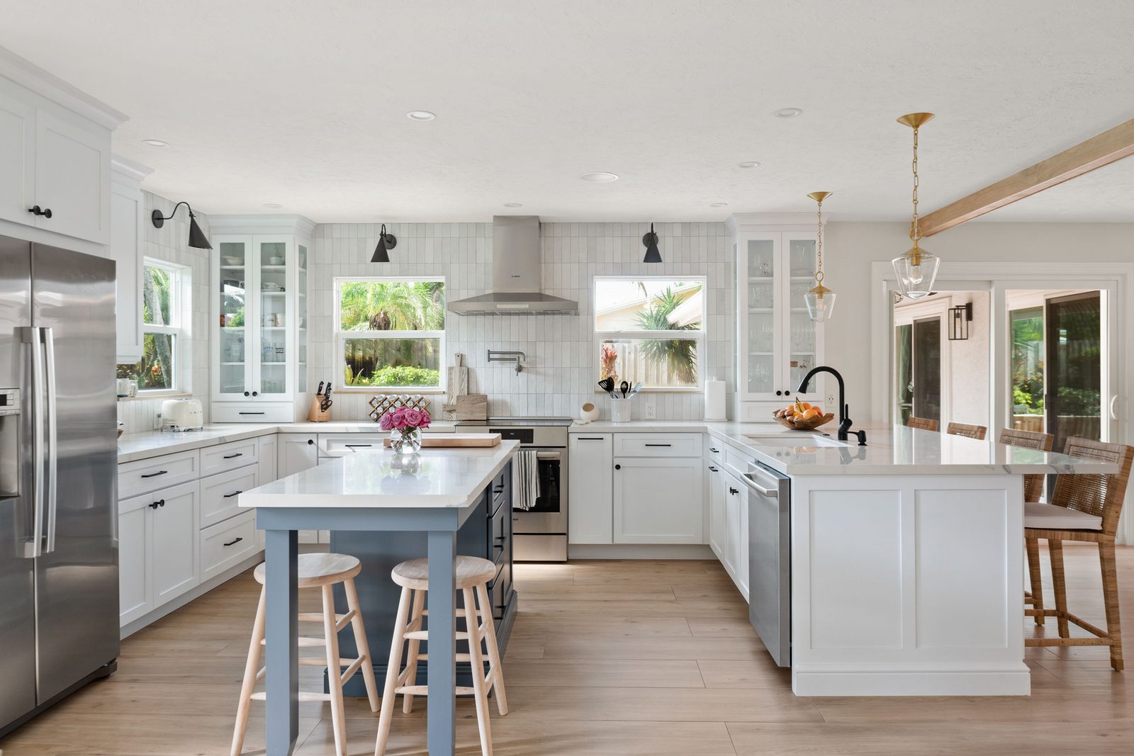 Expansive kitchen remodel with white cabinetry and a contrasting blue island