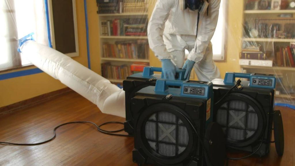 Mold remediation containment barriers and air scrubbers in a hallway