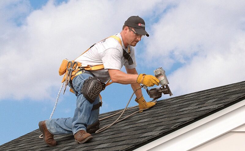 Roofing contractors installing underlayment and shingles on a residential home