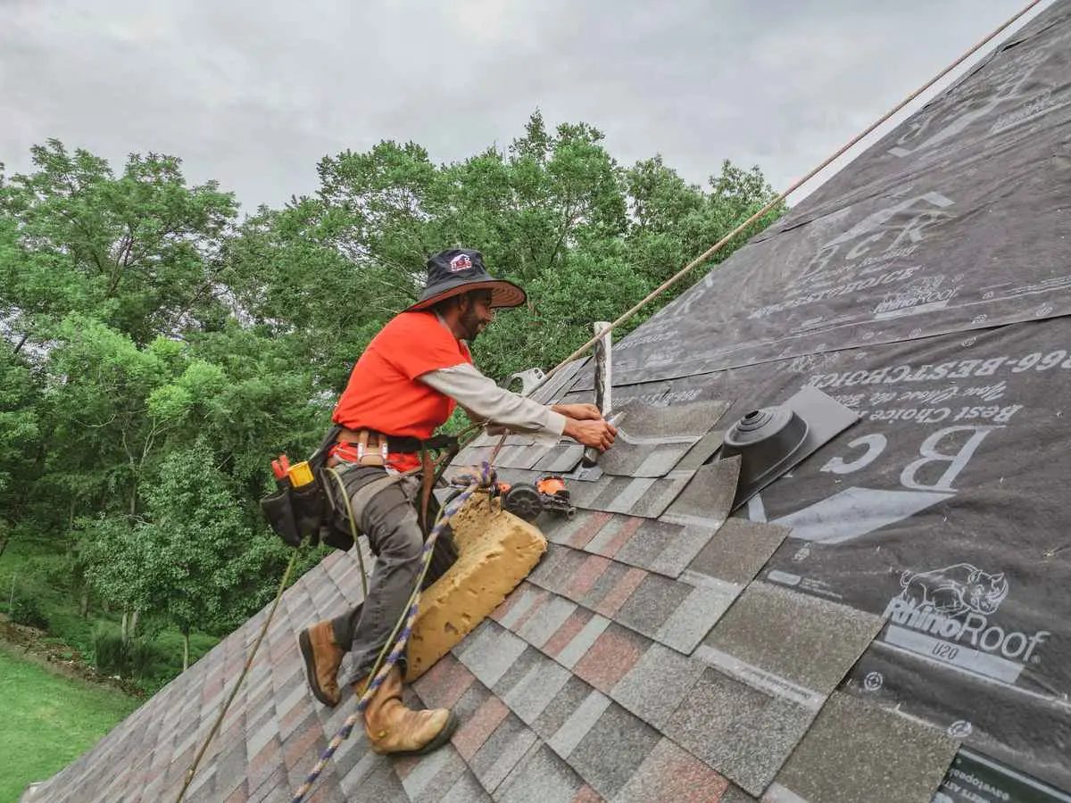 Roofers installing new shingles on a residential roof replacement project